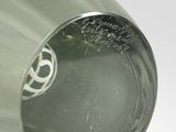 a green glass vase with a silver base