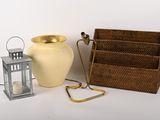 un vase jaune, une lanterne et un panier posés sur une table