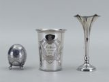 deux vases en argent et un œuf en argent posés sur une table