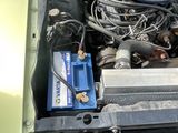 une voiture verte avec une batterie bleue dans son coffre