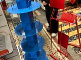 a woman standing in a store looking at a display of toys