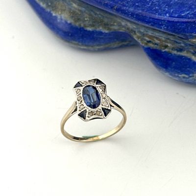an image of a ring with a blue stone in the background