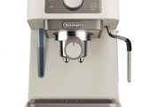 the coffee machine is white and has a black handle
