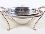 a silver bowl with a handle on it on a stand