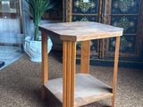 a small wooden table with a plant on it