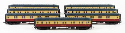 four toy trains are lined up on a white surface