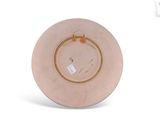 a pink plate with a gold rim sitting on a white surface