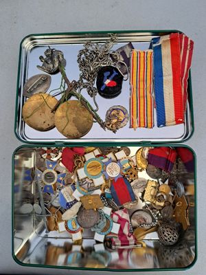 un coffret en métal contenant un assortiment de médailles et d'autres objets