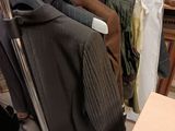 de nombreux vêtements suspendus à un portant dans un magasin de vêtements