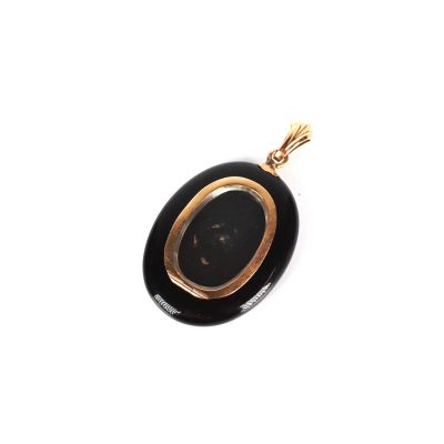 une image représentant un pendentif noir et doré sur fond blanc