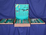 beaucoup d'argenterie dans un coffret posé sur une table bleue