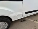 a white van parked in a parking lot next to a building