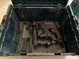 une boîte à outils contenant des outils, posée sur le sol