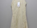 a white dress hanging on a hanger in front of a white wall