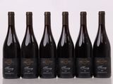 six bouteilles de vin sont alignées sur une table