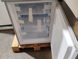 a refrigerator that is sitting on a pallet in a room