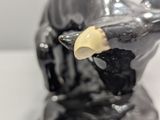 a statue of a bird with a piece of paper on it ' s nose