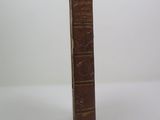 a brown book with writing on it sitting on a white surface