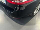 the rear end of a black car parked in a showroom