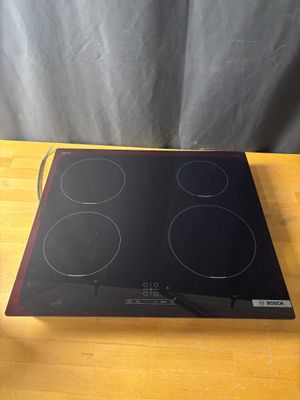 une plaque de cuisson noire et rouge posée sur une table en bois