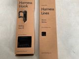 pair of black harnesses in a cardboard box on a white surface