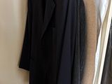 three jackets hanging on a clothes rack in a closet