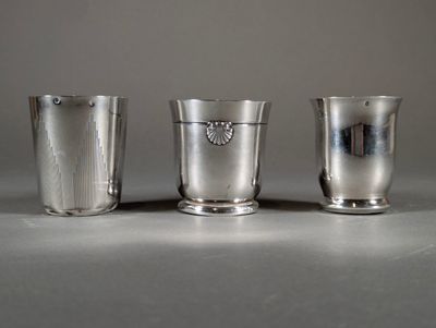 three silver cups sitting on a table next to each other
