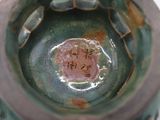 a close up of a green vase with writing on it