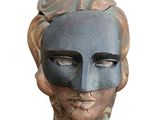 sculpture of a woman ' s face wearing a mask on a pedestal