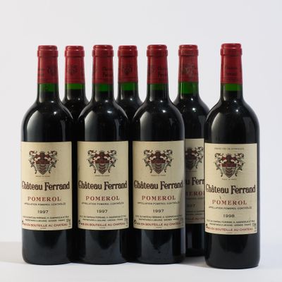 six bouteilles de vin rouge sont alignées sur une surface blanche
