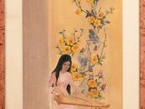 tableau représentant une femme assise à une table avec des fleurs dans un vase