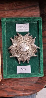 une médaille d'argent et un livre posés sur une table en bois