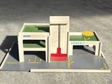 a model of a building with a red chair and a table