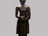 bronze statue of a standing person with a hat on his head