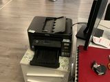 une imprimante posée sur un bureau à côté d'une imprimante