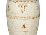 un vase blanc avec un couvercle marron posé sur une surface blanche