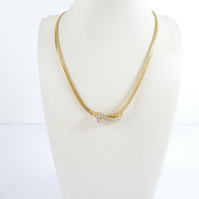 a gold chain necklace with a diamond clasp on a mannequin head