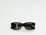 une image représentant une paire de lunettes de soleil noires posées sur une surface blanche