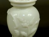 a white vase with a lid sitting on a table