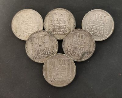 five silver coins sitting on top of each other on a table