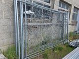 une clôture située à côté d'un bâtiment où se trouvent de nombreux tuyaux