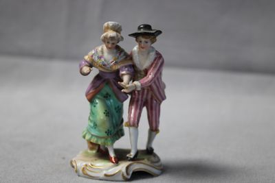 une figurine représentant un homme et une femme debout sur un rocher
