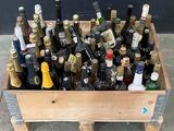 plusieurs bouteilles de vin dans une caisse en bois posée par terre