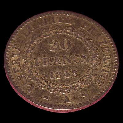une vieille pièce d'or avec un liseré rouge sur fond noir