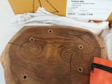une boîte sur laquelle est posé un morceau de bois et un sac muni d'une étiquette