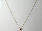 a gold necklace with a small elephant on it ' s neck