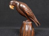 une sculpture en bois représentant un oiseau perché sur une souche de bois