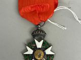 une photo représentant une médaille entourée d'un ruban, posée sur une table