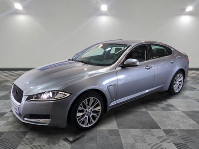 the silver jaguar car is parked in a large room