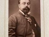 an old photo of a man with a beard wearing a suit and tie